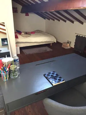 a table in a room with a bed in the background at La Capucine in Cavaillon