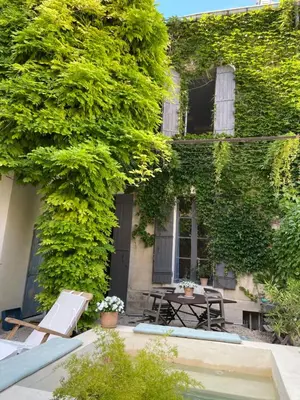an ivy covered building with a table and chairs at La Capucine in Cavaillon
