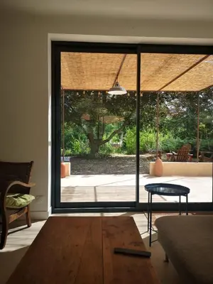 a living room with a large sliding glass door at Le Petit Paradis in Saint-Martin-de-Castillon