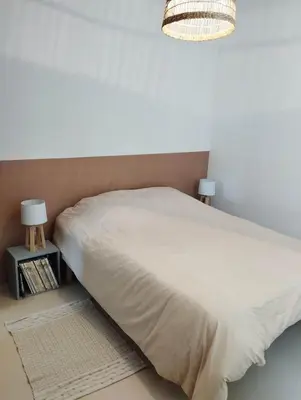 a bedroom with a white bed and two lamps at Le Petit Paradis in Saint-Martin-de-Castillon