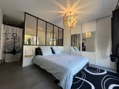 a bedroom with a large bed and a chandelier at Villa Spacieuse avec Piscine in Entraigues-sur-la-Sorgue