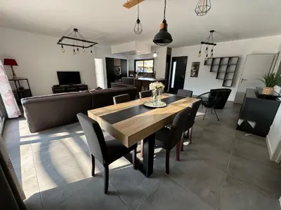 a dining room and living room with a table and chairs at Villa Spacieuse avec Piscine in Entraigues-sur-la-Sorgue