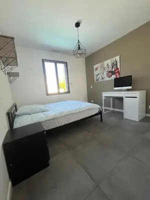 a bedroom with a bed and a desk and a window at Villa Spacieuse avec Piscine in Entraigues-sur-la-Sorgue