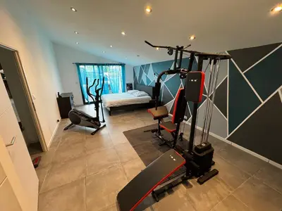 a living room with a gym with a treadmill at Villa Spacieuse avec Piscine in Entraigues-sur-la-Sorgue