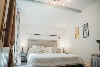 a bedroom with a bed with a sign on the wall at Mas de l'air in Noves
