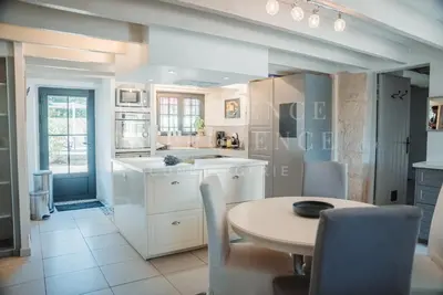 a kitchen with a table and a table and chairs at Mas de l'air in Noves