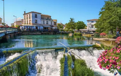 a river with a waterfall in a city at 3 Bedroom Awesome Home In Carpentras in Carpentras