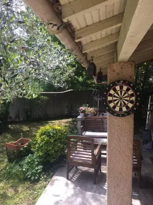 a clock on the side of a patio with a bench at Maison provençale avec piscine in Loriol-du-Comtat