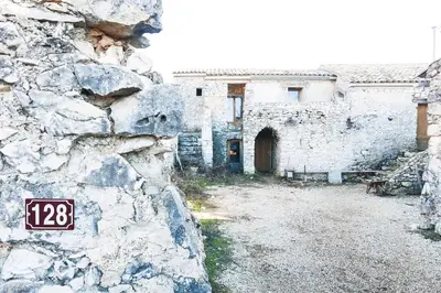 an old stone building with a sign on a wall at JAS provençal pour 6 personnes à 2mn de la Grange de Javon in Monieux