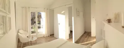 a white room with two white chairs and a mirror at Le Cabanon de Marie in Saignon