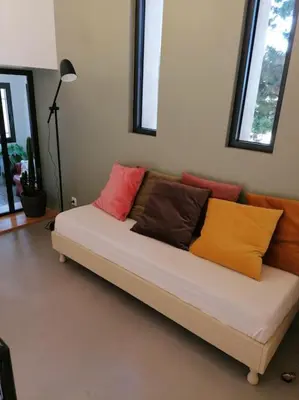 a couch with colorful pillows on it in a room at Gîte cosy au coeur du Luberon in Lagnes