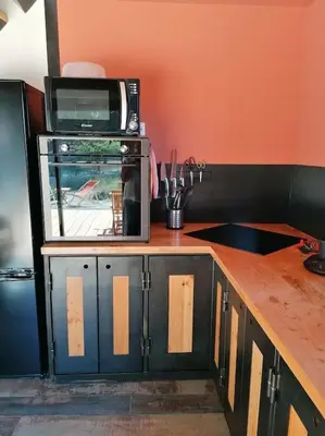 a kitchen with a microwave on top of a counter at Gîte cosy au coeur du Luberon in Lagnes