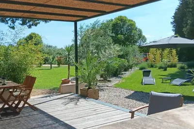 a patio with a table and chairs in a yard at Gîte cosy au coeur du Luberon in Lagnes