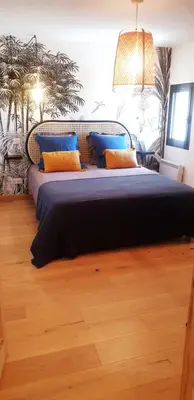 a bedroom with a large bed with blue and yellow pillows at Gîte cosy au coeur du Luberon in Lagnes