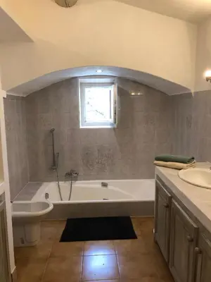 a bathroom with a bath tub and a sink at L'Atelier de la Baronnie - Lubéron in Cabrières-dʼAvignon
