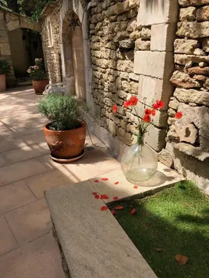 a vase with flowers in it sitting on the grass at L'Atelier de la Baronnie - Lubéron in Cabrières-dʼAvignon