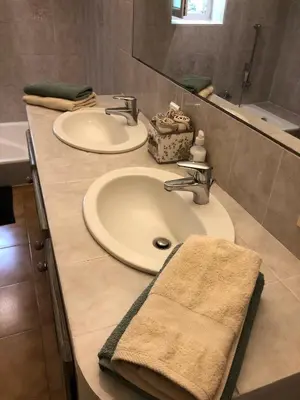 a bathroom counter with two sinks and a mirror at L'Atelier de la Baronnie - Lubéron in Cabrières-dʼAvignon