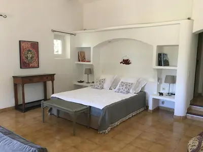 a bedroom with a bed and a table in it at L'Atelier de la Baronnie - Lubéron in Cabrières-dʼAvignon