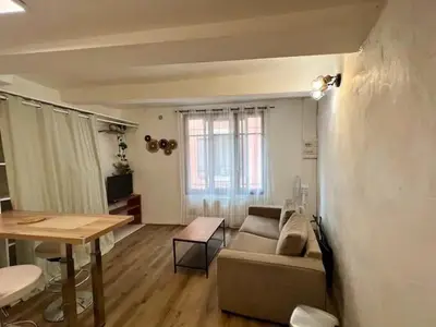 a living room with a couch and a table at Studio centre historique à Carpentras in Carpentras