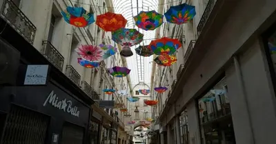 a row of colorful umbrellas hanging from a building at Studio centre historique à Carpentras in Carpentras