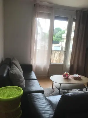 a living room with a black leather couch and a table at Ayoug Chambre Individuelle Chez Habitat in Carpentras