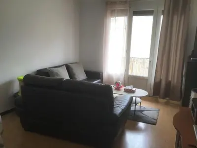 a living room with a black couch and a table at Ayoug Chambre Individuelle Chez Habitat in Carpentras