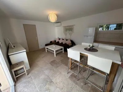 a kitchen and living room with a table and chairs at Maison de vacances en campagne in Cavaillon