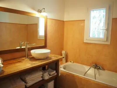 a bathroom with a sink and a tub and a mirror at Holiday Home in Villes-sur-Auzon with Pool in Villes-sur-Auzon