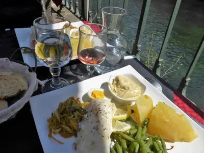 a white plate of food on a table with wine glasses at Holiday Home in Villes-sur-Auzon with Pool in Villes-sur-Auzon