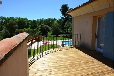 a wooden walkway leading to a balcony with a pool at Villa au calme et sans vis à vis , proche du village in La Bastide-des-Jourdans