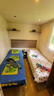 a bedroom with a bed with a surfboard on it at Mobil Home au calme Camping 4 Cadenet in Cadenet