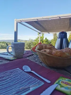 a table with a basket of bread and a cup at La Bella Vista in Villelaure