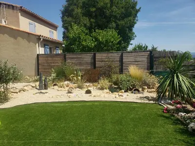 a backyard with a fence and a green lawn at La Bella Vista in Villelaure