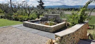 a stone fountain in the middle of a garden at La Bella Vista in Villelaure