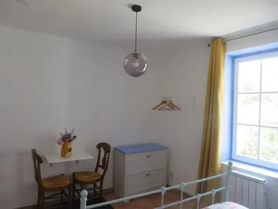a bedroom with a bed and a desk and a window at Auberge de la petite casserole in Revest-des-Brousses