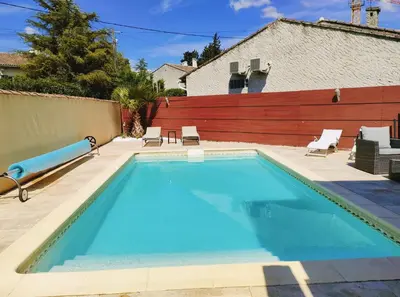 a swimming pool in a backyard with a wooden fence at Appart 1 ch rénové avec piscine in Morières-lès-Avignon
