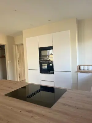 a kitchen with white cabinets and a glass table at Villa PERNOISE in Pernes-les-Fontaines