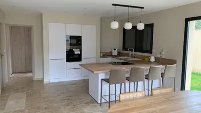 a kitchen with a counter and a island with chairs at Villa PERNOISE in Pernes-les-Fontaines