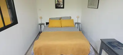 a small bedroom with a bed with yellow pillows at Location appartement dans mas provençal in Monteux