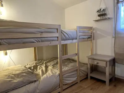 a bedroom with two bunk beds and a table at Mazet provençal in Eyguières