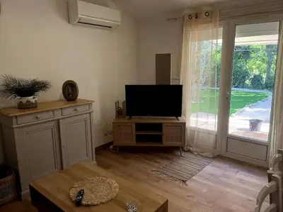 a living room with a flat screen tv on a stand at Mazet provençal in Eyguières