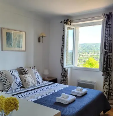 a bedroom with a bed with towels on top of it at Le Jardin des Oliviers in Apt