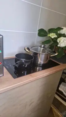 a counter with three pots and pans on a stove at Le Jardin des Oliviers in Apt