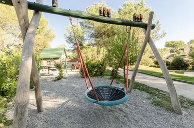 a swing yard with two swings and a basket at Les Mas et Villas de Pont Royal en Provence - maeva Home - Villa duplex moderne et vintage 3 pièces 6 personnes climatisée - Prestige - super Home MAE-4211 in Mallemort