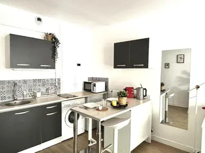 a kitchen with white cabinets and a counter top at Studio Lumineux avec Terrasse in Aix-en-Provence
