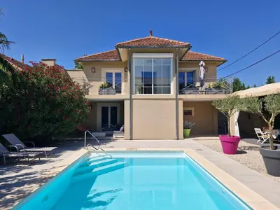 a villa with a swimming pool in front of a house at La Villa Jasmin - RENDEZ-VOUS EN PROVENCE in Monteux