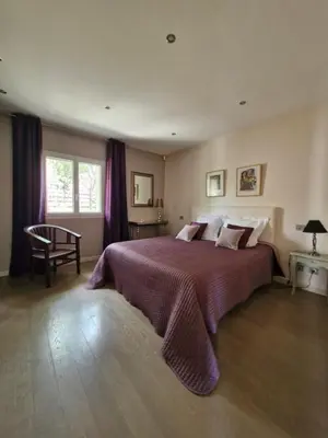 a bedroom with a large bed with a purple blanket at La Villa Jasmin - RENDEZ-VOUS EN PROVENCE in Monteux