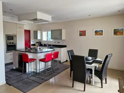 a kitchen with a island with red chairs and a table at La Villa Jasmin - RENDEZ-VOUS EN PROVENCE in Monteux