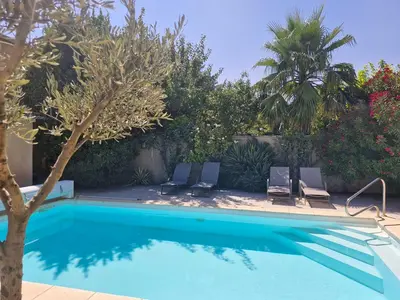 a swimming pool with two chairs and a tree at La Villa Jasmin - RENDEZ-VOUS EN PROVENCE in Monteux