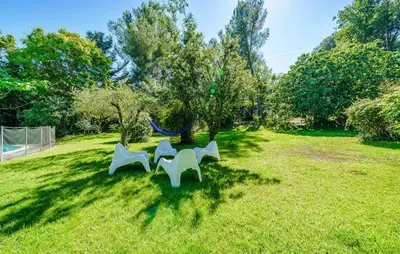 two white benches sitting in the grass in a yard at Cozy Home In Aix-En-Provence With Wifi in Aix-en-Provence